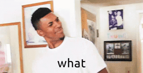 A Man In A White Shirt Is Standing In A Room With A Picture On The Wall And The Word What Written On It . GIF