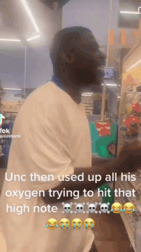A Man In A White Shirt Is Standing In A Store And Using Oxygen To Try To Hit That High Note . GIF