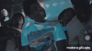 A Man In A White Shirt Is Standing In Front Of A Crowd With Make A Gif.com On The Bottom Right GIF