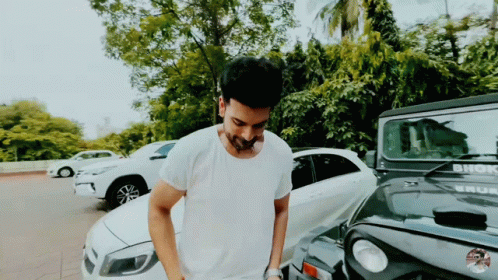 A Man In A White Shirt Is Standing In Front Of A Jeep That Says Bhok GIF