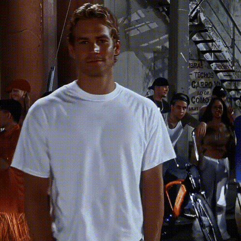 A Man In A White Shirt Is Standing In Front Of A Sign That Says Techos Carro GIF