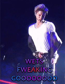 A Man In A White Shirt Is Standing In Front Of A Sign That Says Wets Fweaking Goo00000 GIF