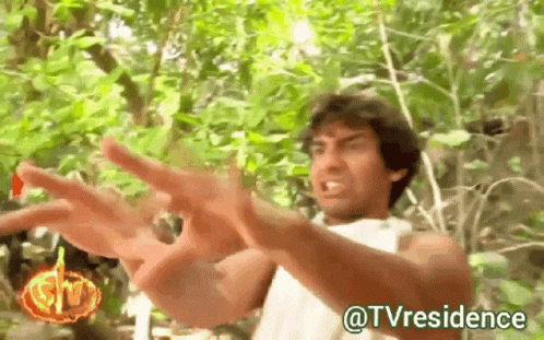 A Man In A White Shirt Is Standing In The Woods With His Arms Outstretched And The Words @Tvresidence Below Him GIF