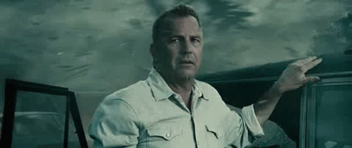 A Man In A White Shirt Is Standing Next To A Car In The Dark . GIF
