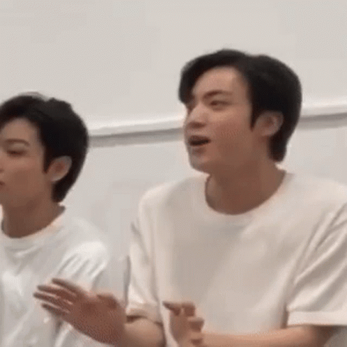 A Man In A White Shirt Is Standing Next To Another Man . GIF