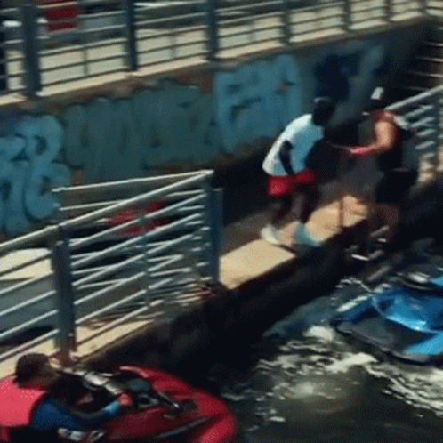 A Man In A White Shirt Is Standing On A Dock Next To A Jet Ski GIF