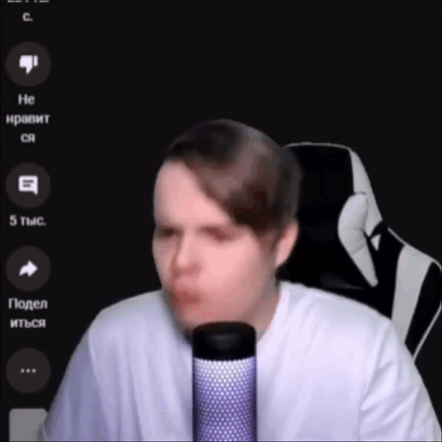 A Man In A White Shirt Is Talking Into A Microphone . GIF