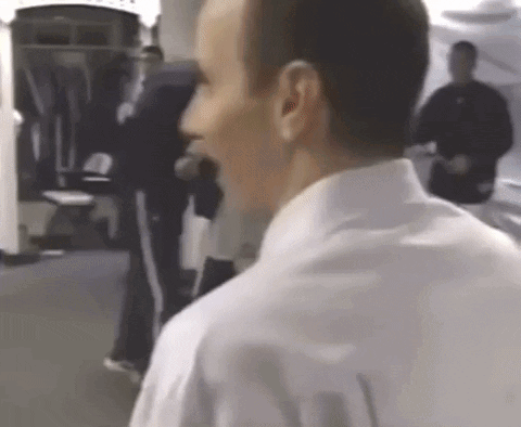 A Man In A White Shirt Is Talking To Another Man GIF