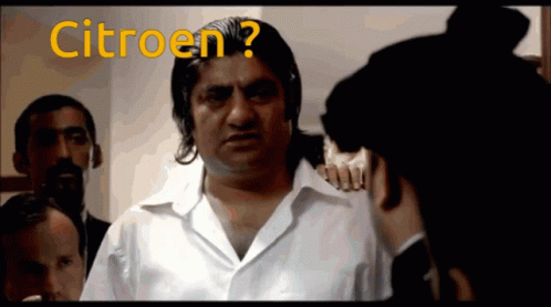 A Man In A White Shirt Is Talking To Another Man With The Word Citroen Written On The Screen GIF