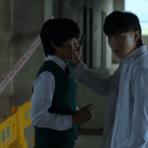 A Man In A White Shirt Is Touching Another Man 'S Face With His Hand GIF