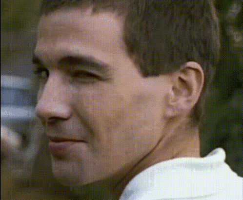Man In White Shirt Looking Over Shoulder GIF
