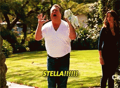 A Man In A White Shirt Shouts Stella While Holding A Pair Of Shoes GIF