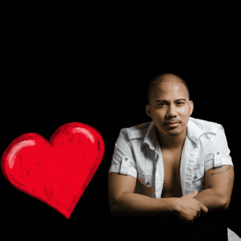 A Man In A White Shirt Sits In Front Of A R & R Music House Logo GIF
