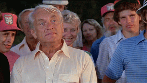 A Man In A White Shirt Stands In Front Of A Crowd Of People Wearing Hats With The Letter J On Them GIF