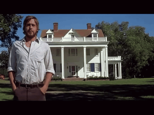 A Man In A White Shirt Stands In Front Of A Large White House GIF
