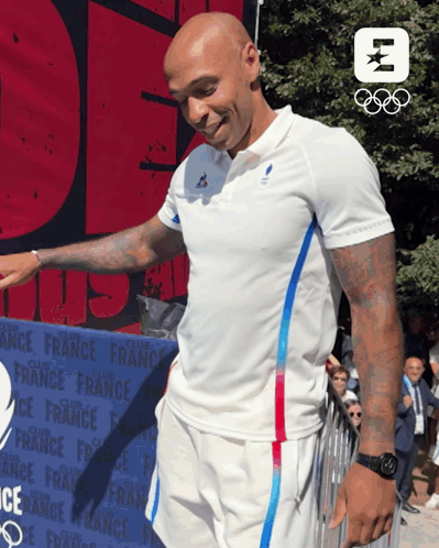 A Man In A White Shirt Stands In Front Of A Sign That Says France GIF