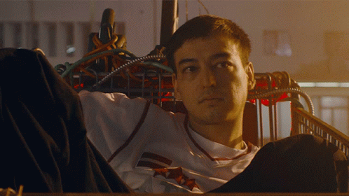 A Man In A White Shirt With A Red And White Stripe On The Sleeves GIF