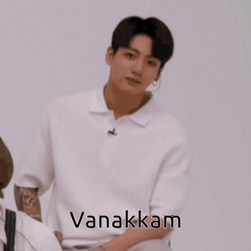 A Man In A White Shirt With His Hands Folded And The Word Vanakkam On The Bottom GIF