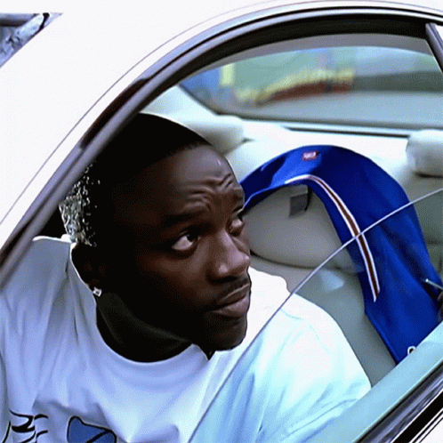 A Man In A White Shirt With The Letter R On It Is Sitting In A Car GIF