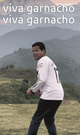 a man in a white shirt with the number 1 on it stands in a field