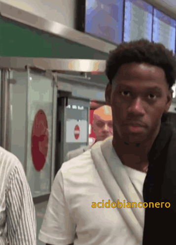 A Man In A White Shirt With The Word Acidobianconero On The Bottom GIF