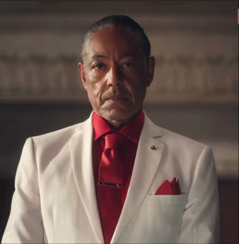 A Man In A White Suit Has A Red Tie GIF