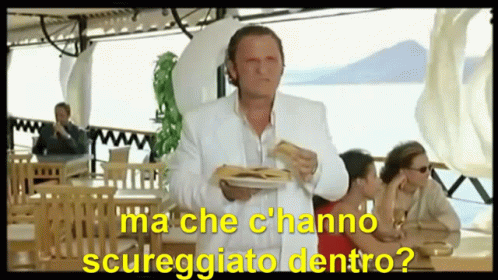 A Man In A White Suit Is Holding A Plate Of Food With The Words Ma Che C'hanno Scureggiato Dentro GIF