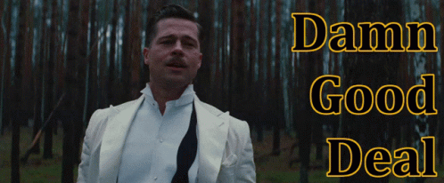 A Man In A White Suit Is Standing In A Forest With The Words Damn Good Deal Above Him GIF