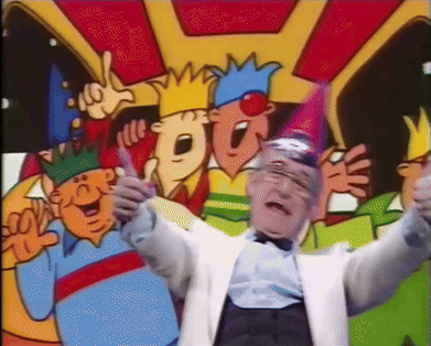A Man In A White Suit Is Standing In Front Of A Group Of Cartoon Characters Wearing Party Hats GIF