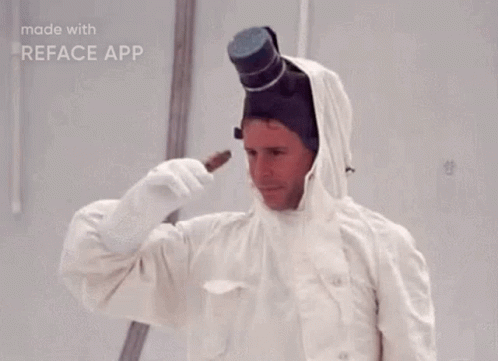 A Man In A White Suit With A Top Hat On His Head Is Holding Something In His Hand . GIF