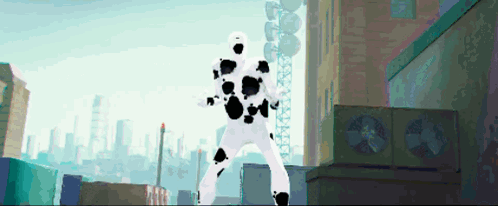 A Man In A White Suit With Black Spots Is Standing In A City GIF