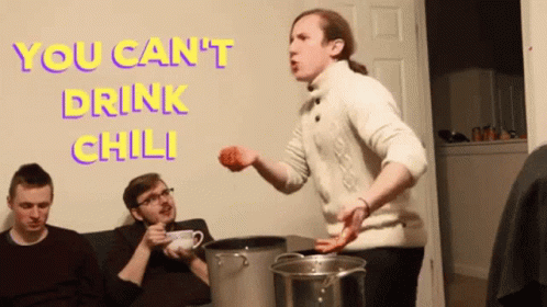 A Man In A White Sweater Is Standing In Front Of A Wall With The Words " You Can 'T Drink Chili " On It GIF