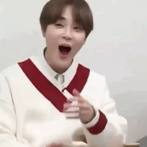 A Man In A White Sweater With A Red Stripe On The Sleeves Is Making A Funny Face With His Mouth Open . GIF