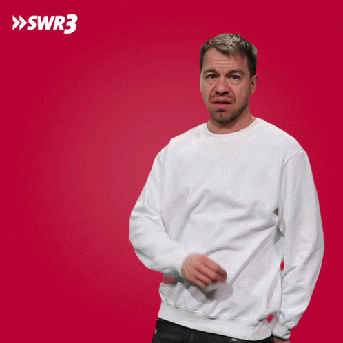 A Man In A White Sweatshirt Is Pointing At Something In Front Of A Red Background With The Letters Swr3 On It GIF