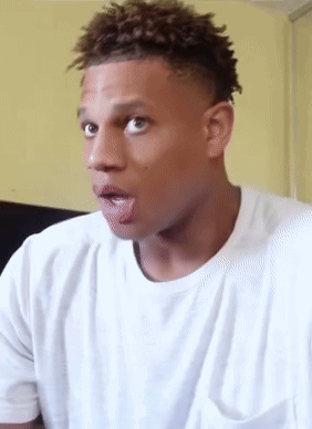 A Man In A White T-Shirt Is Sticking His Tongue Out GIF
