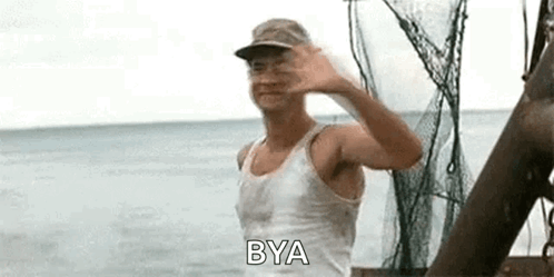 A Man In A White Tank Top And Hat Is Waving At The Camera While Standing On A Boat In The Ocean . GIF