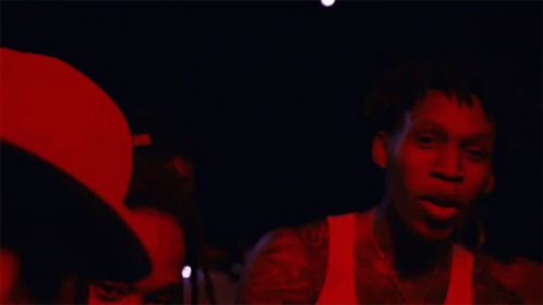 A Man In A White Tank Top Has A Tattoo Of A Horseshoe On His Arm GIF