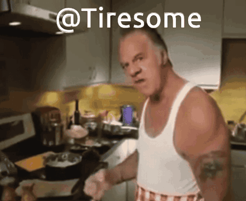 A Man In A White Tank Top Is Cooking In A Kitchen And The Words @Tiresome Are Above Him GIF
