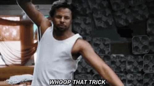 A Man In A White Tank Top Is Dancing With His Arms Outstretched And Saying Whoop That Trick . GIF