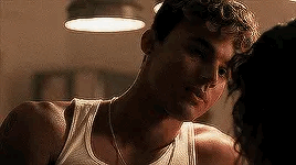 A Man In A White Tank Top Is Kissing A Woman On The Forehead . GIF