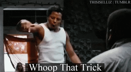 A Man In A White Tank Top Is Pointing At Another Man In A Boxing Ring And Saying `` Whoop That Trick '' . GIF