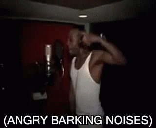 A Man In A White Tank Top Is Singing Into A Microphone With The Words Angry Barking Noises Below Him GIF