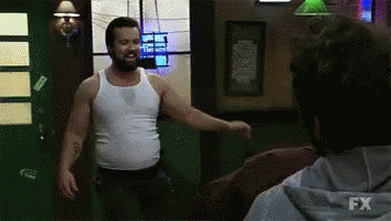 A Man In A White Tank Top Is Standing Next To Another Man In A Fx Hoodie .. GIF