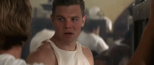 A Man In A White Tank Top Is Talking To A Woman . GIF