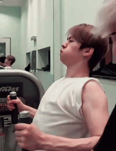 A Man In A White Tank Top Is Using A Treadmill That Says Fitness On It GIF