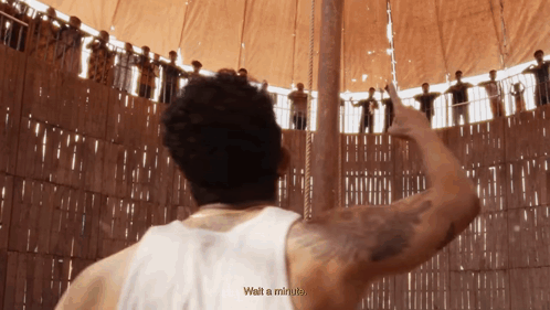A Man In A White Tank Top Says Wait A Minute In Front Of A Crowd GIF