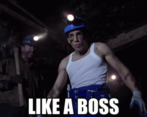 A Man In A White Tank Top Stands In A Cave With The Words Like A Boss Written Below Him GIF