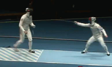 A Man In A White Uniform Is Holding A Sword In Front Of Another Man GIF