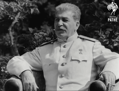 A Man In A White Uniform Sits In A Chair With The Word Pathe On The Bottom Right GIF