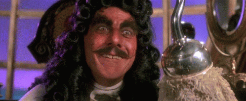 A Man In A Wig And Mustache Is Smiling And Holding A Hook . GIF